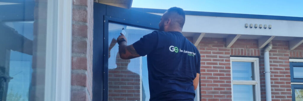 Man vervangt ruit in tuindeur